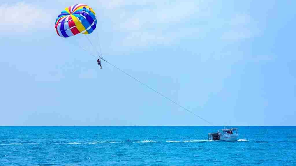 青い空と青い海。パラセーリングが行われている画像