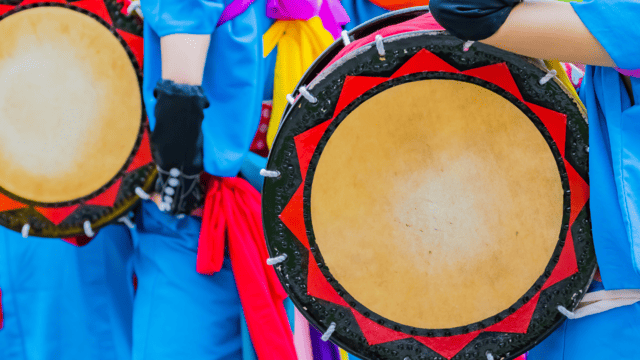 青色の衣装に、太鼓がうつるお祭りの画像